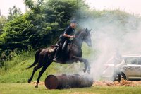 Policjant na koniu przeskakującym przez palącą się słomę